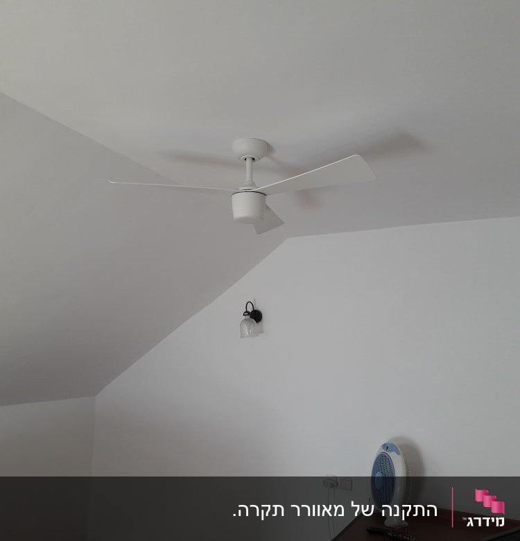 מאוורר תקרה לבן מותקן על תקרה משופעת